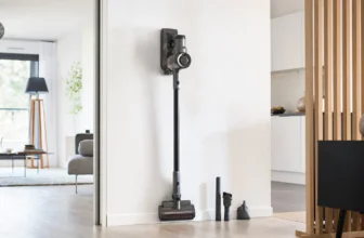 Aspirateur balai sans fil rangé sur son support mural dans un appartement lumineux