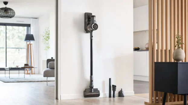 Aspirateur balai sans fil rangé sur son support mural dans un appartement lumineux
