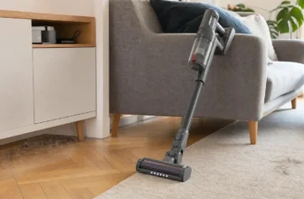 Aspirateur sans fil utilisé sur parquet et tapis dans un salon