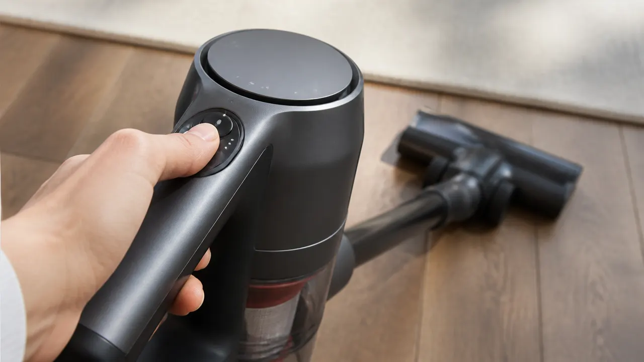 Main réglant la puissance d’un aspirateur balai sans fil